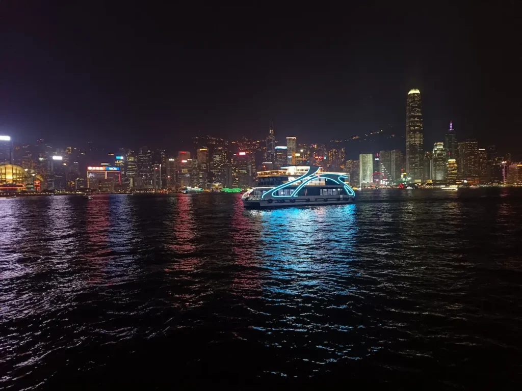 Barco navegando durante el espectáculo de luces del muelle de Hong Kong